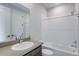 Bathroom features a modern vanity, bathtub, and shower with white subway tile at 1418 Hudson Pl, Longmont, CO 80501