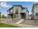Modern townhome showcasing its gray facade, brick accents, and professionally landscaped front yard at 1418 Hudson Pl, Longmont, CO 80501