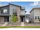 Modern townhome featuring a stylish gray facade with brick accents and a well-maintained front yard at 1418 Hudson Pl, Longmont, CO 80501