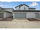 Spacious two-car garage with gray siding and a paved driveway at 1418 Hudson Pl, Longmont, CO 80501