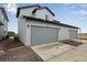 Spacious two-car garage with gray siding and a paved driveway at 1418 Hudson Pl, Longmont, CO 80501
