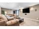 Finished basement with plush seating, a large-screen TV, and ambient lighting, creating a cozy entertainment area at 6303 Ellingwood Point Pl, Castle Rock, CO 80108