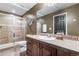 Well-lit bathroom featuring a glass shower, vanity with sink, and neutral brown tiling at 6303 Ellingwood Point Pl, Castle Rock, CO 80108