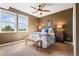 Inviting bedroom featuring a ceiling fan, two windows with outside view, and neutral decor at 6303 Ellingwood Point Pl, Castle Rock, CO 80108