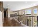 Hallway with hardwood floors, black metal railing, and multiple windows offering scenic views from the upper level at 6303 Ellingwood Point Pl, Castle Rock, CO 80108