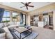Open-concept living room with access to the kitchen and outdoor deck with scenic views at 6303 Ellingwood Point Pl, Castle Rock, CO 80108