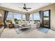 Bright living room featuring large windows, a ceiling fan, and comfortable seating area with views of the landscape at 6303 Ellingwood Point Pl, Castle Rock, CO 80108
