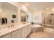 Bright primary bathroom with double sinks, a soaking tub, glass shower, and a large walk-in closet at 14521 Vancouver Pl, Parker, CO 80134