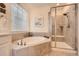 Bright primary bathroom featuring a large soaking tub and a glass-enclosed shower at 14521 Vancouver Pl, Parker, CO 80134