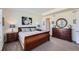 Well-lit main bedroom featuring stylish furnishings, including a dresser and nightstands and matching lamps at 14521 Vancouver Pl, Parker, CO 80134