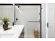 Modern bathroom featuring a glass-enclosed shower, bright white tiles, neutral vanity, and sleek black fixtures at 2920 W Parkside Pl, Denver, CO 80221