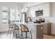 Modern kitchen features white cabinets, stainless steel appliances, quartz counters and island with bar stool seating at 2920 W Parkside Pl, Denver, CO 80221