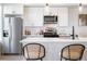 Bright kitchen features white subway tile backsplash, stainless steel appliances, quartz countertops, and counter seating at 2920 W Parkside Pl, Denver, CO 80221