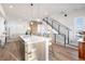 Open concept with modern kitchen island, staircase, and living area featuring sleek finishes at 2920 W Parkside Pl, Denver, CO 80221