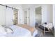 Comfortable main bedroom with sliding barn door access to ensuite bath, walk-in closet, and stylish decor at 2920 W Parkside Pl, Denver, CO 80221