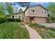 Charming two-story home with brick accents, manicured lawn, mature trees, and a two car garage at 6621 E Peakview Pl, Centennial, CO 80111