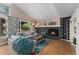 Cozy living room with fireplace, wood floors, sliding glass doors to backyard and comfortable sofa at 6621 E Peakview Pl, Centennial, CO 80111