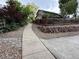Charming home with a wooden fence, stone accents, and lush landscaping along a sidewalk at 6621 E Peakview Pl, Centennial, CO 80111