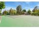 Beautiful tennis court surrounded by lush trees and greenery on a bright day at 6621 E Peakview Pl, Centennial, CO 80111