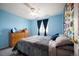 Bright bedroom featuring blue walls, a ceiling fan, and a comfortable bed with a gray comforter at 11207 Day Star Ct, Parker, CO 80138