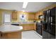 Bright kitchen featuring wood cabinets, a center island, and black appliances at 11207 Day Star Ct, Parker, CO 80138