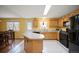 Bright kitchen featuring wood cabinets, a center island, black appliances, and a door to the backyard at 11207 Day Star Ct, Parker, CO 80138