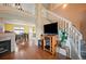 Open living space with hardwood floors, fireplace, and a view of the dining room and staircase at 11207 Day Star Ct, Parker, CO 80138