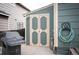 View of the shed in the backyard with painted door, hose and grill in the foreground at 11207 Day Star Ct, Parker, CO 80138