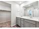 Bathroom featuring double sinks with white quartz countertops and grey cabinets at 19019 E 94Th Pl, Commerce City, CO 80022