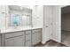 Bathroom featuring double sinks with white quartz countertops and grey cabinets at 19019 E 94Th Pl, Commerce City, CO 80022