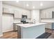 Modern kitchen with gray cabinets, quartz countertops, stainless steel appliances, and large island at 19019 E 94Th Pl, Commerce City, CO 80022
