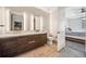 Bathroom with a double vanity, illuminated mirrors, a toilet, and doorway to the bedroom at 4200 W 17Th Ave # 327, Denver, CO 80204