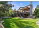 Exterior of a two-story home featuring a spacious deck with stairs leading to a well-maintained lawn and backyard at 14152 W Evans Cir, Lakewood, CO 80228