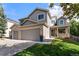 Charming two-story home featuring a two-car garage, brick accents, and well-manicured lawn at 14152 W Evans Cir, Lakewood, CO 80228