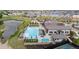 Aerial view of community pool, clubhouse, and surrounding residential area with a pond nearby at 5142 N Quemoy Ct, Aurora, CO 80019