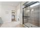 Modern bathroom with glass-enclosed shower, tiled floor, and linen closet at 5142 N Quemoy Ct, Aurora, CO 80019