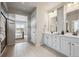 En-suite bathroom featuring double sinks, tiled floor, and glass-enclosed shower at 5142 N Quemoy Ct, Aurora, CO 80019