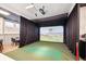 This golf simulator room has a large projector screen, seating area, and sports equipment at 5142 N Quemoy Ct, Aurora, CO 80019