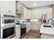 Modern kitchen featuring stainless steel appliances, white cabinets, and stylish backsplash at 5142 N Quemoy Ct, Aurora, CO 80019