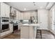 Well-equipped kitchen with stainless steel appliances, white cabinetry, and a center island with seating at 5142 N Quemoy Ct, Aurora, CO 80019
