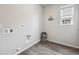 Laundry area with gray vinyl flooring, window, and utility connections ready for appliances at 5142 N Quemoy Ct, Aurora, CO 80019