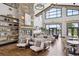 Inviting lounge area featuring a stone fireplace, comfortable seating, and large windows for natural light at 5142 N Quemoy Ct, Aurora, CO 80019
