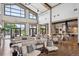 Open lounge area with high ceilings, modern furnishings, tables, and a kitchen with an island bar at 5142 N Quemoy Ct, Aurora, CO 80019