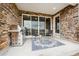 Covered patio boasts stone accents, outdoor seating, and a grill, perfect for entertaining at 5142 N Quemoy Ct, Aurora, CO 80019