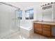 Bright bathroom features a walk-in shower, soaking tub, and vanity with sink and natural light at 15028 Clayton St, Thornton, CO 80602