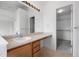 Bright bathroom features a single sink vanity and a doorway leading to a spacious walk-in closet at 15028 Clayton St, Thornton, CO 80602