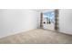 A bright bedroom with neutral carpet and a window with views of the neighborhood at 15028 Clayton St, Thornton, CO 80602