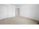 A neutral bedroom with soft carpet features a sliding closet door and entry to the next room at 15028 Clayton St, Thornton, CO 80602