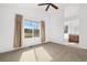 Bedroom with neutral carpet, ceiling fan, large window, and attached bathroom at 15028 Clayton St, Thornton, CO 80602