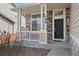Inviting front porch with stone pillars, a black front door, and clear address numbers at 15028 Clayton St, Thornton, CO 80602